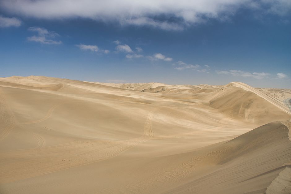Stunning view of Namib Desert sand dunes under a bright blue sky, capturing the essence of adventure.